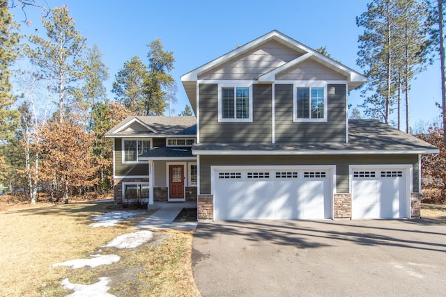 view of front of property featuring aphalt driveway, stone siding, and an attached garage