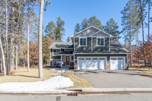 view of front of property featuring aphalt driveway, an attached garage, and stone siding