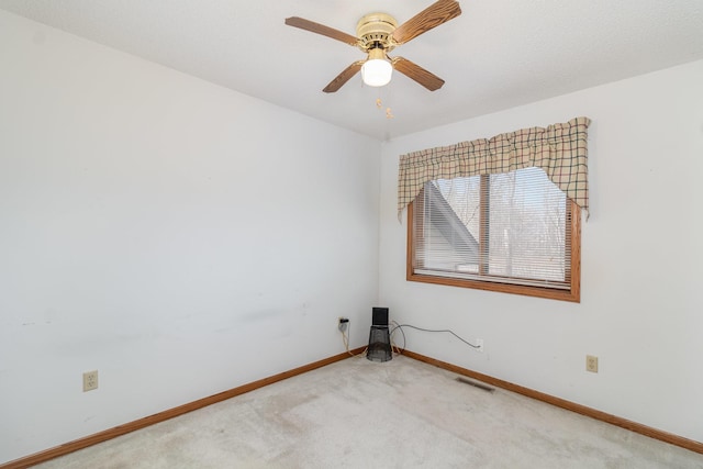 spare room with visible vents, baseboards, carpet, and a ceiling fan