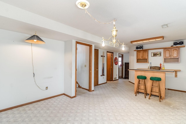 kitchen with decorative light fixtures, a kitchen breakfast bar, a peninsula, and baseboards