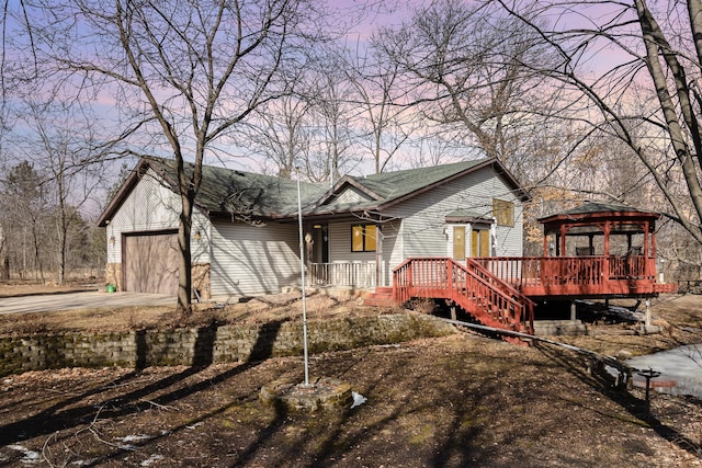 view of front of house with a gazebo, concrete driveway, a garage, and roof with shingles