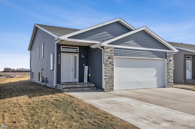 ranch-style home with roof with shingles, an attached garage, concrete driveway, a front lawn, and stone siding