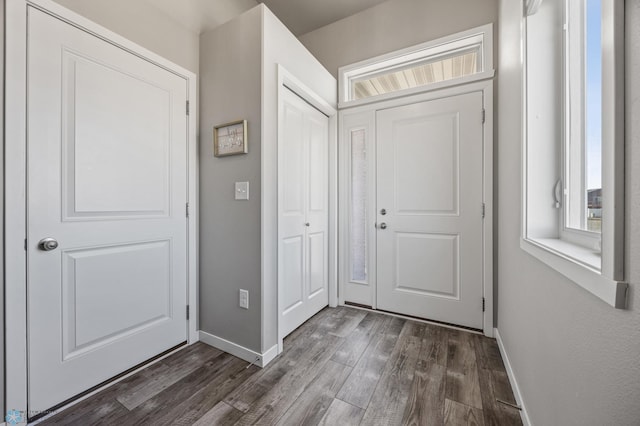 foyer entrance with dark wood finished floors and baseboards