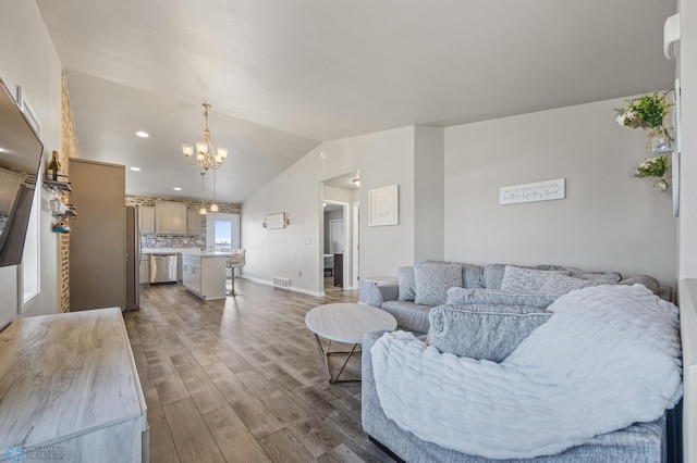 living area featuring visible vents, wood finished floors, baseboards, lofted ceiling, and a chandelier