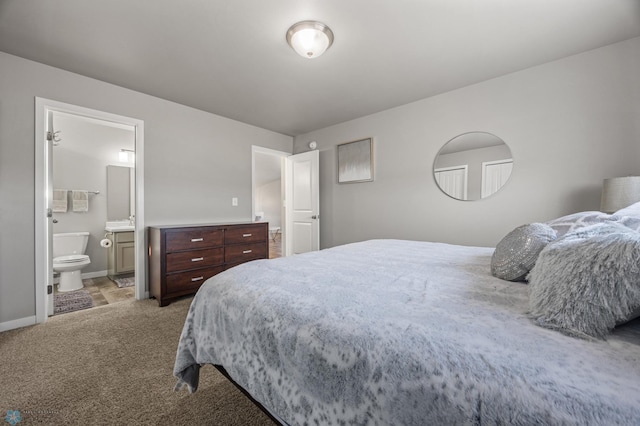 bedroom featuring light colored carpet, baseboards, and ensuite bathroom