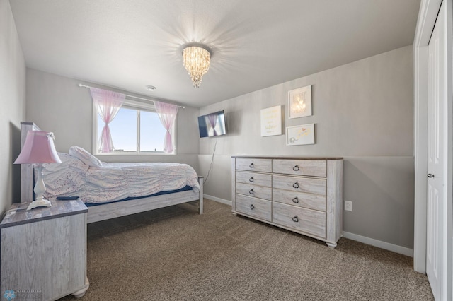 carpeted bedroom with baseboards and a chandelier