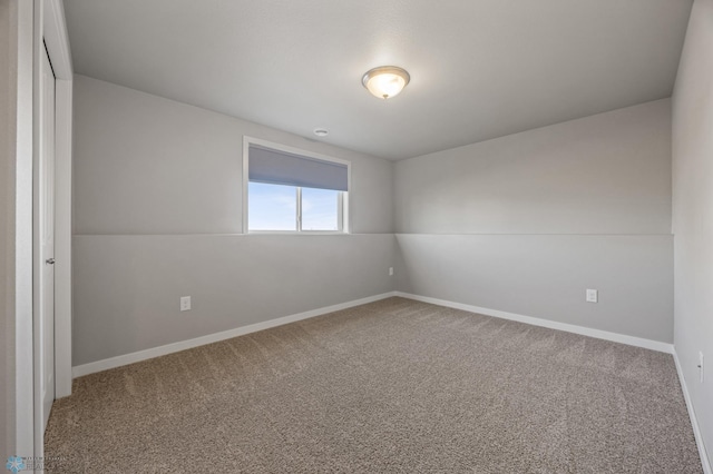 carpeted spare room with baseboards