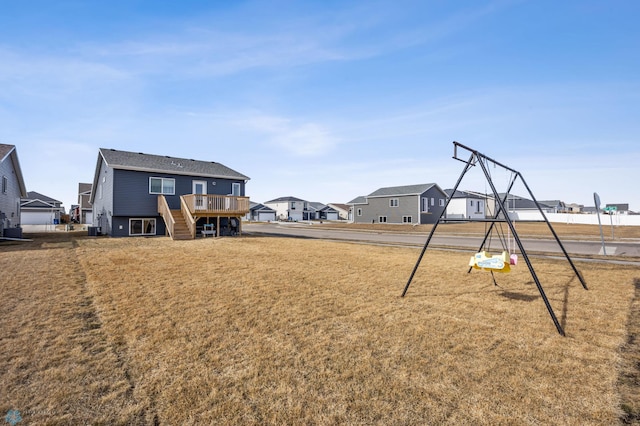 view of yard featuring a residential view, stairs, a playground, and a deck