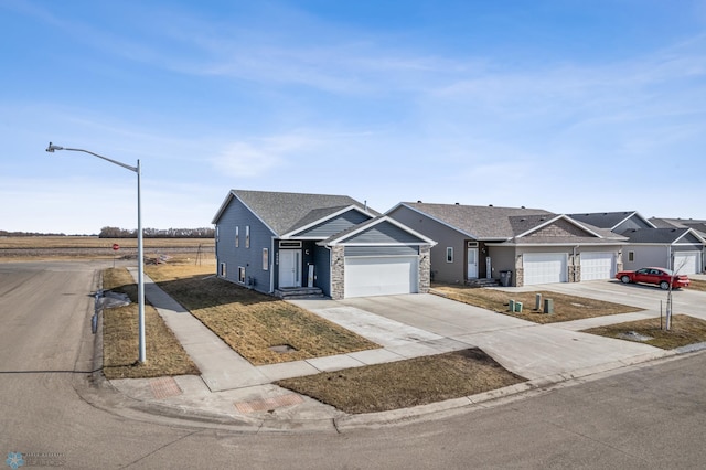 view of front of house with a garage, stone siding, and concrete driveway