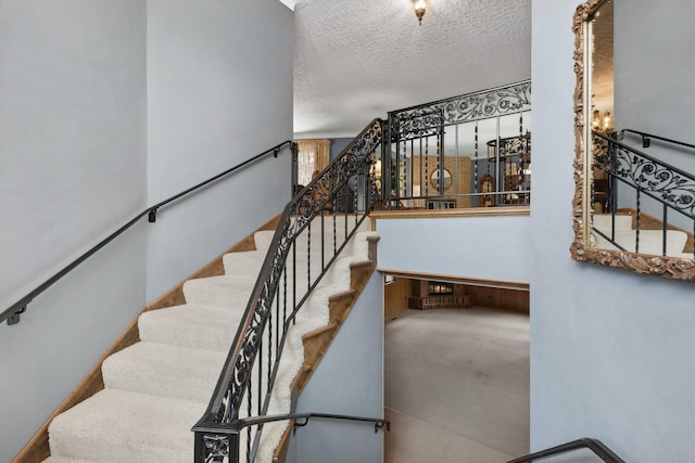 staircase featuring a textured ceiling