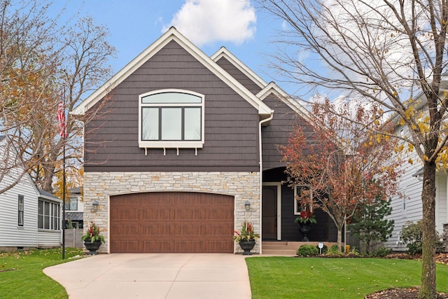 view of front of house featuring a front yard, an attached garage, stone siding, and driveway