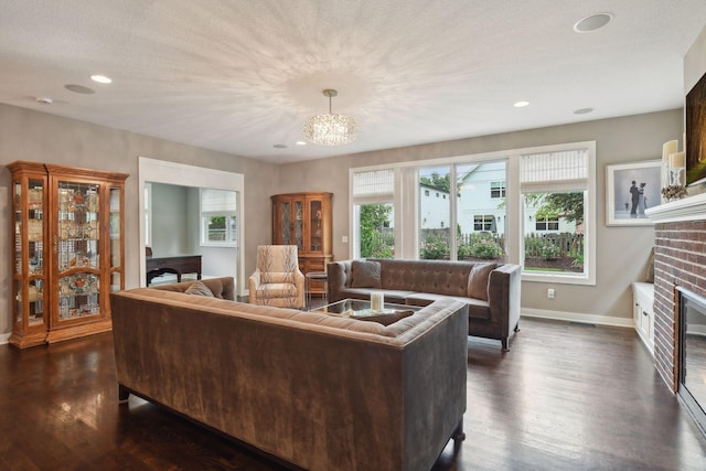 living area with recessed lighting, baseboards, a brick fireplace, and dark wood finished floors