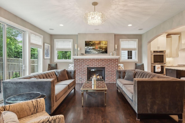 living room featuring recessed lighting, a fireplace, and dark wood-type flooring