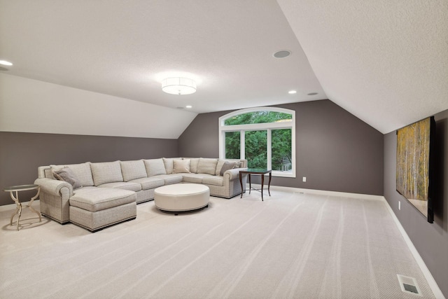 carpeted living area featuring baseboards, a textured ceiling, and lofted ceiling