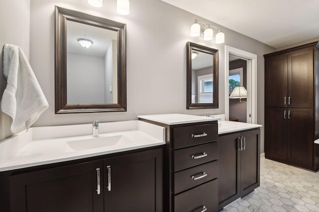 bathroom featuring tile patterned flooring, two vanities, and a sink