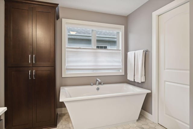 bathroom with baseboards and a soaking tub