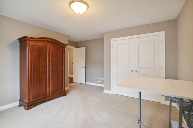 bedroom with visible vents, baseboards, light colored carpet, and a closet