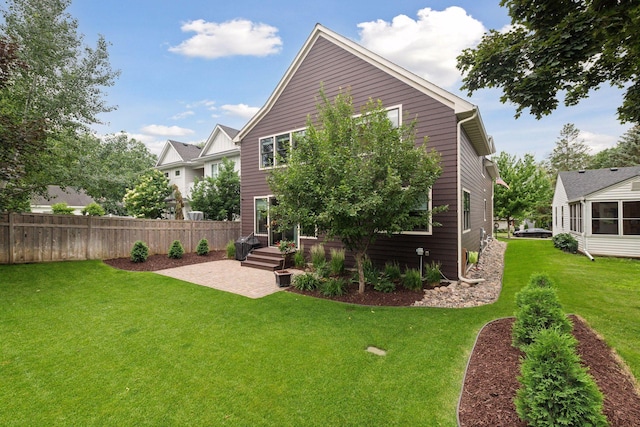 back of property with a patio, a yard, and fence