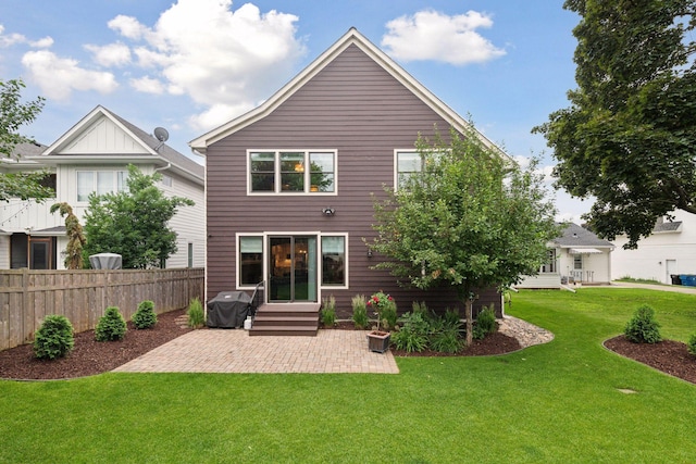 rear view of property featuring a patio, a yard, and fence