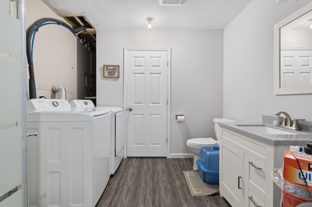 laundry area with a sink, separate washer and dryer, and dark wood-style floors