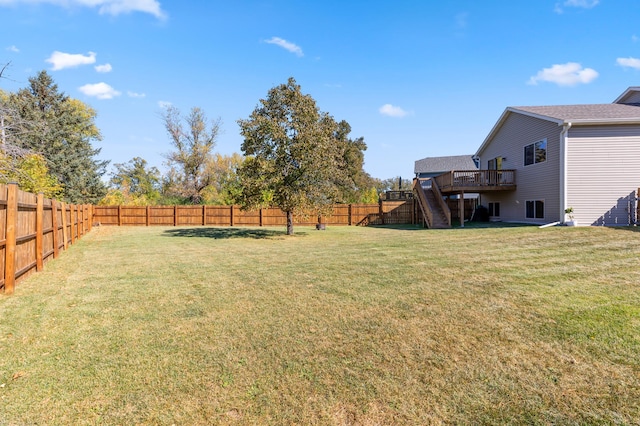 view of yard with a wooden deck, stairs, and a fenced backyard