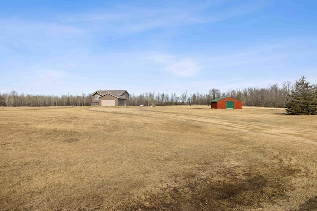 view of yard featuring an outbuilding, driveway, a garage, and a pole building