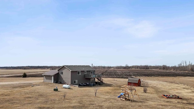 view of yard with an outbuilding, a rural view, and a shed