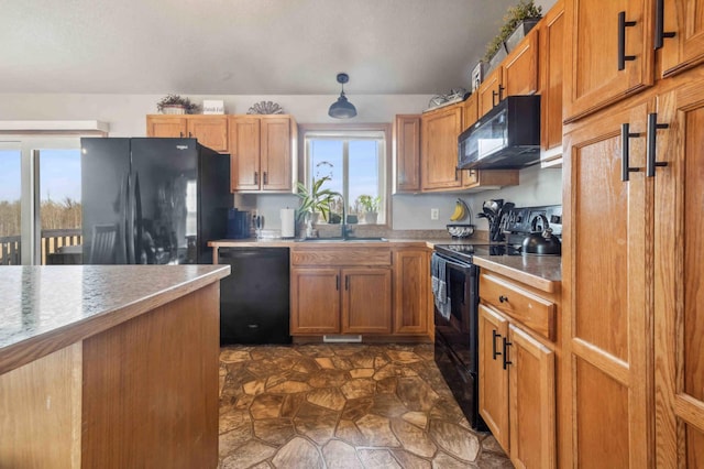 kitchen featuring black appliances, light countertops, brown cabinets, and a sink