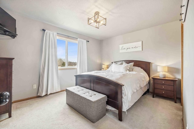 carpeted bedroom featuring baseboards and an inviting chandelier