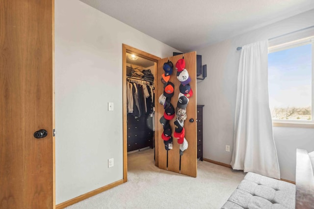 carpeted bedroom featuring a walk in closet, baseboards, and a closet