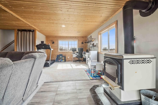 living room with wooden walls, wood ceiling, and a wood stove