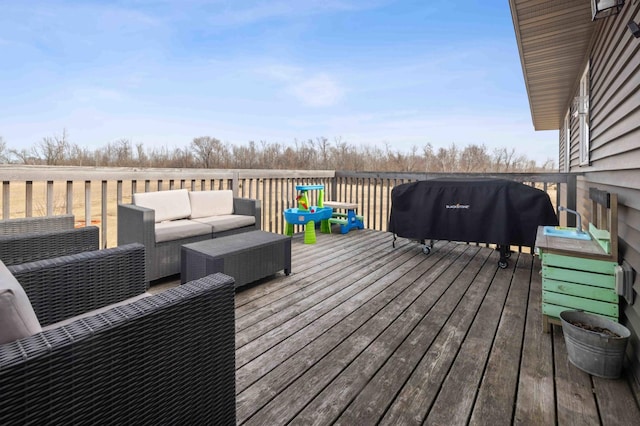 deck with an outdoor living space and a grill