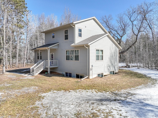 snow covered house with roof with shingles