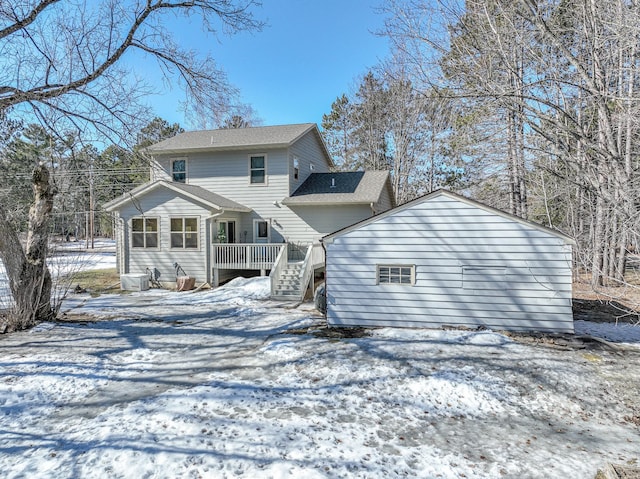 snow covered rear of property featuring a deck and central AC