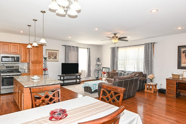 living area featuring recessed lighting, baseboards, wood finished floors, and ceiling fan with notable chandelier