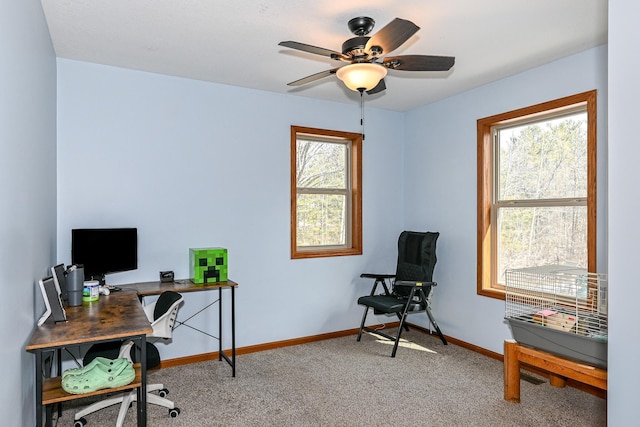 home office featuring light colored carpet, baseboards, and ceiling fan