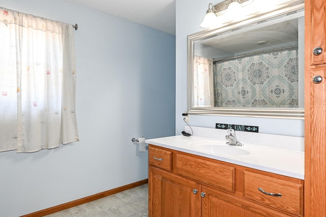 bathroom with vanity, a shower with shower curtain, and baseboards