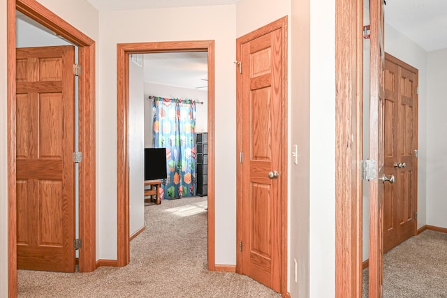 hall with baseboards and carpet