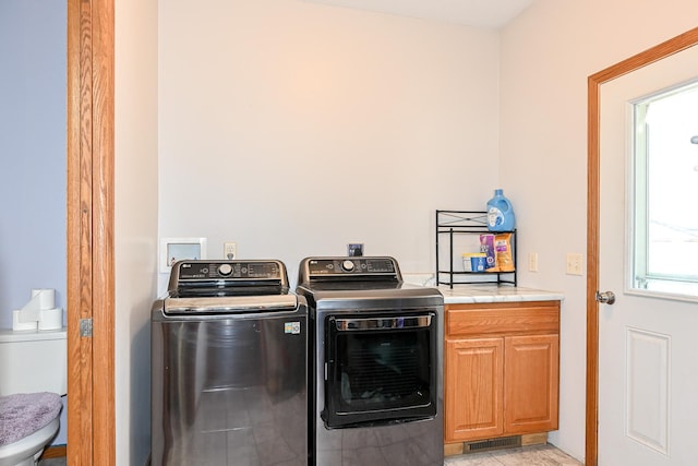 laundry room with washer and dryer, cabinet space, and visible vents