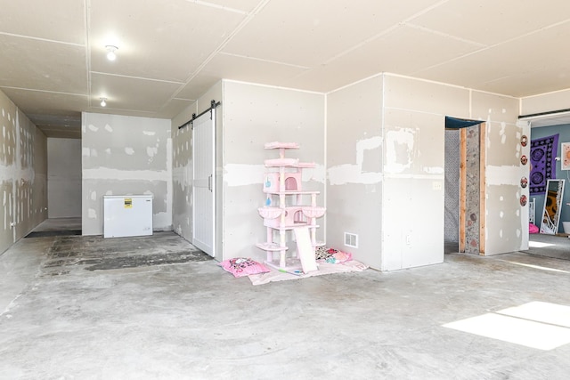 below grade area featuring a barn door and visible vents