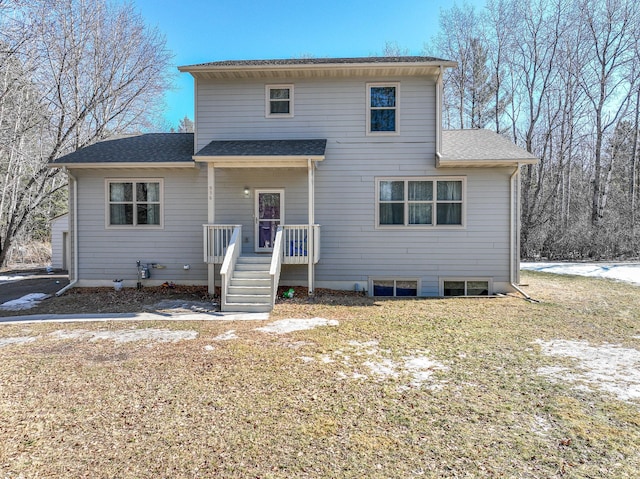 rear view of house with roof with shingles