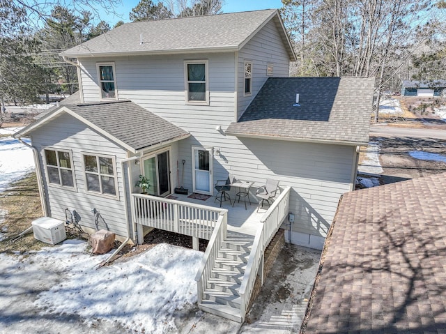 rear view of house with a wooden deck, a shingled roof, and stairs