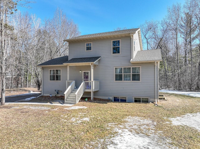 rear view of house featuring roof with shingles