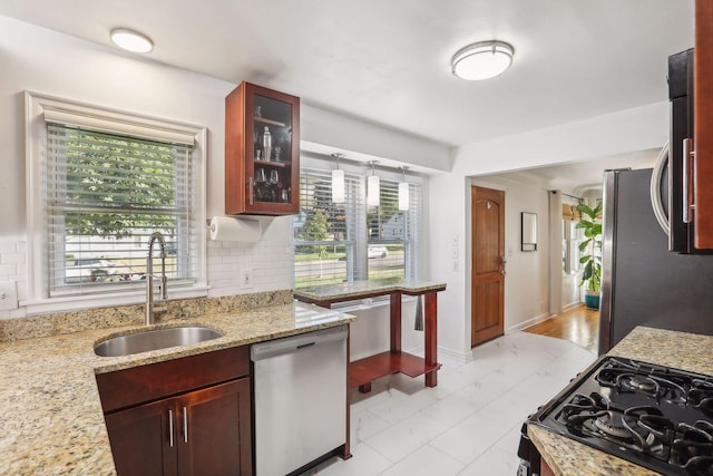 kitchen with a sink, plenty of natural light, backsplash, and stainless steel appliances