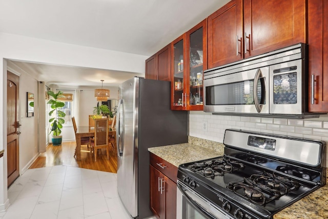 kitchen with dark brown cabinets, backsplash, and appliances with stainless steel finishes