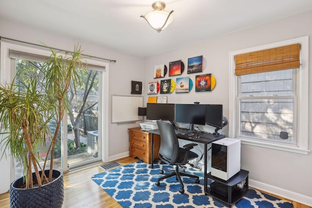 office area featuring visible vents, baseboards, and wood finished floors