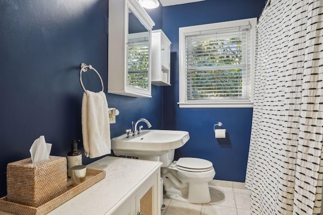 bathroom featuring a sink, toilet, and tile patterned flooring