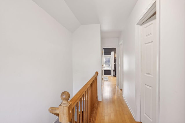 corridor featuring an upstairs landing and light wood finished floors