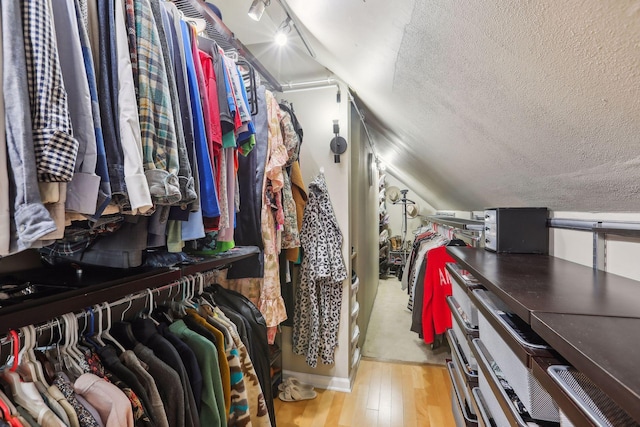 spacious closet with vaulted ceiling and wood-type flooring