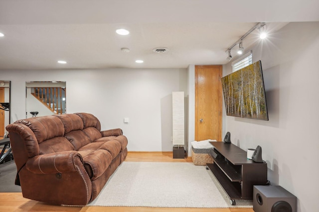 living room featuring stairway, recessed lighting, rail lighting, and wood finished floors